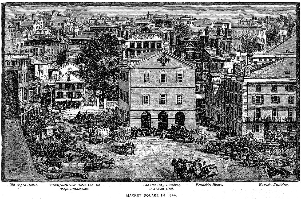 An engraving shows a large open square full of horse-drawn carts and people.