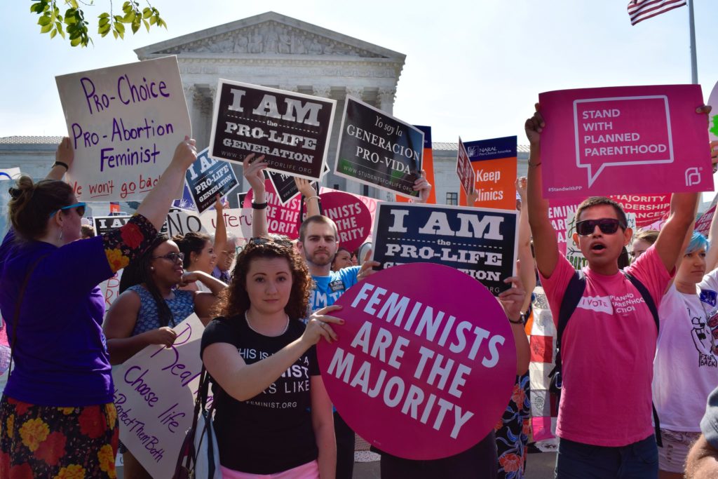 Image of protestors holding pro-choice and anti-abortion signs outside the Supreme Court of the United States.