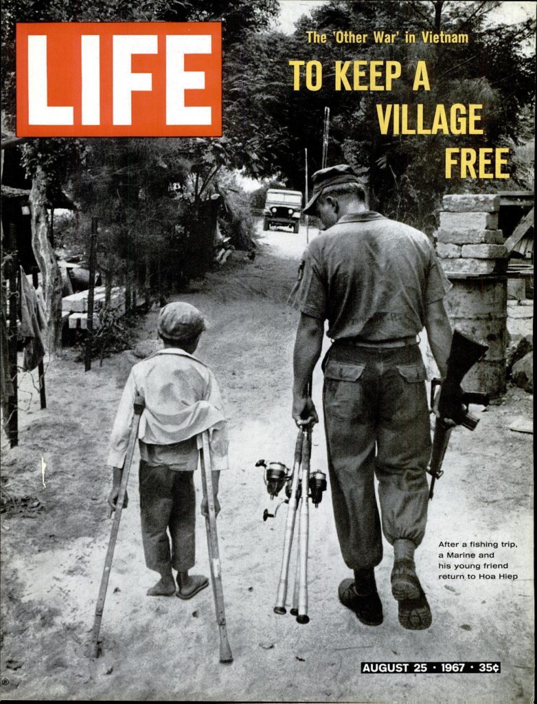 A *Life* cover image of a U.S. Marine and South Vietnamese child walking down a road with fishing rods in hand.