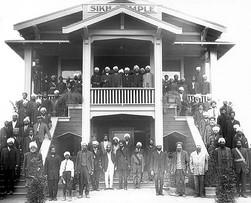A Sikh temple in Stockton, CA. Indian migrants stand outside on the porch and stairs.