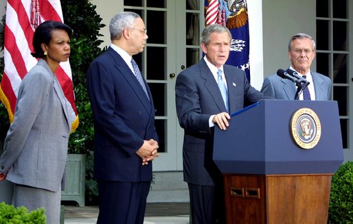 U.S. President George W. Bush (at podium) discusses his plan for peace in the Middle East as National Security Advisor Condoleezza Rice (left), Secretary of State Colin Powell (center) and Secretary of Defense Donald Rumsfeld (right) stand by his side in the White House Rose Garden on June 24, 2002.