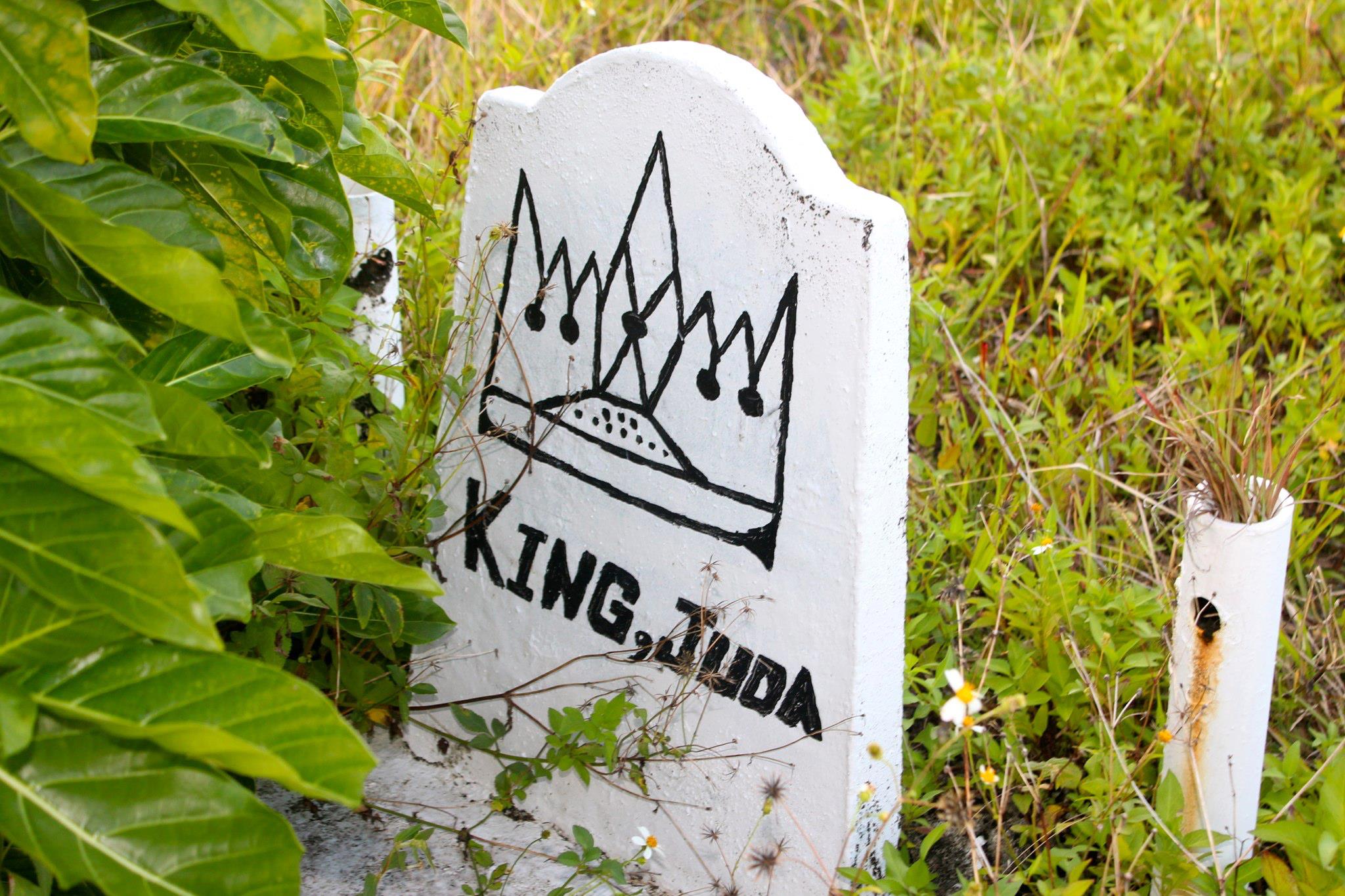 A white gravestone with the words "King Juda" and a drawing of a crown.